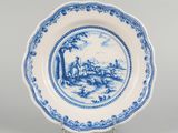 a blue and white plate with a landscape scene on it