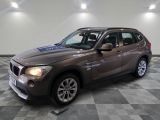 la bmw x1 est garée dans une grande pièce au sol en damier
