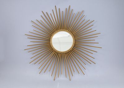 un miroir doré en forme d'étoile accroché au mur