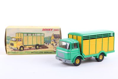 a green toy truck with a yellow trailer in front of a box