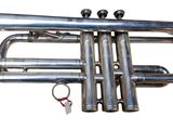 a silver trumpet that is sitting on a white surface