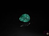 a close up of a green diamond on a black surface