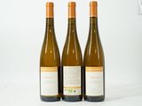 trois bouteilles de vin posées sur une table blanche