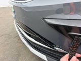 a person holding a remote control in front of a car
