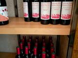 many bottles of wine sitting on a wooden shelf