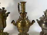 three antique brass urns are sitting next to each other on a white surface