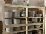 de nombreuses assiettes et bols empilés sur les étagères de la cuisine