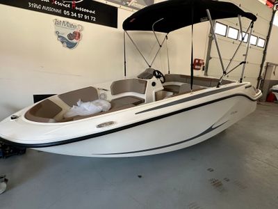 un bateau blanc avec un auvent noir dans un garage