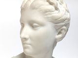 white marble bust of a woman with braided hair