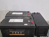 Deux batteries sont posées sur une palette dans un entrepôt