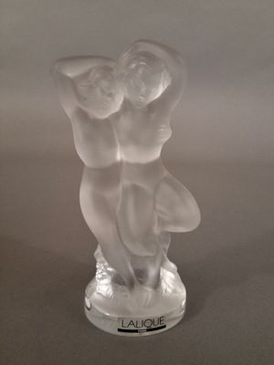 une figurine en verre représentant deux personnes se tenant la main