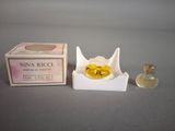 a small bottle of perfume next to a small box of perfume