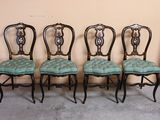 four chairs are lined up against a wall in a room
