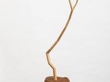 sculpture of a tree branch on a white pedestal with a white background
