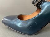someone is wearing a pair of blue shoes with a buckle on them