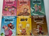 several children ' s books are lined up on a white surface
