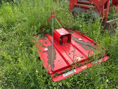 une machine rouge qui est garée dans l'herbe