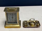 a small clock and a small tray on a table