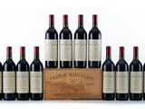 six bottles of red wine are lined up in a wooden crate