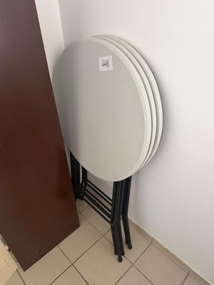 une pile d'assiettes blanches posée sur une table à côté d'une porte marron