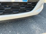 a close up of a car ' s grille with a blue sticker on it