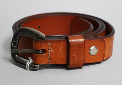 une ceinture marron avec une boucle métallique sur un fond blanc