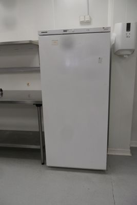 a white refrigerator sitting in a kitchen next to a table