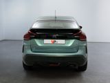 the rear end of a green car in a white room