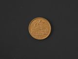 a close up of a gold coin on a black surface