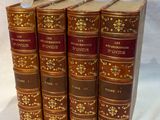 four books are lined up in a row on a white surface