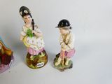 three figurines of a man and a woman on a table