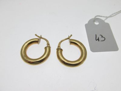 a pair of gold hoop earrings on a white background