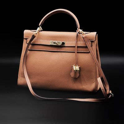 a brown leather handbag on a black background