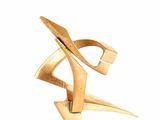 gold plated sculpture of a stylized design on a white background