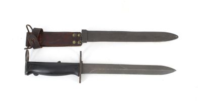 two knives with leather sheaths on them on a white surface