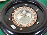 a black and orange roulet wheel on a green table