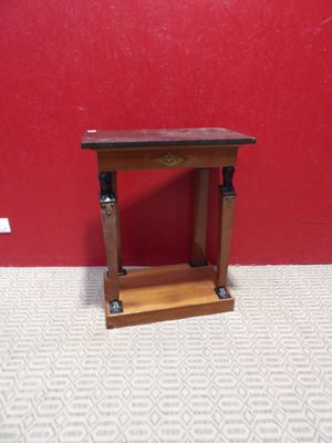 une petite table en bois posée à même le sol, près d'un mur rouge