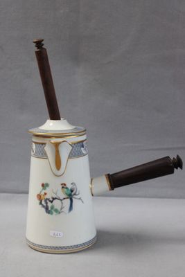 une cafetière blanche avec une poignée en bois posée sur une table