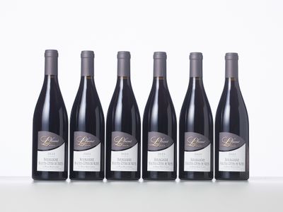 six bottles of wine are lined up on a table