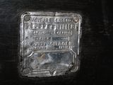 a metal plaque on the side of a black suitcase