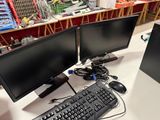 two computer monitors and a keyboard on a table