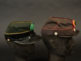 two hats on a mannequin head with a black background