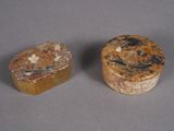 two pieces of stone with designs on them sitting next to each other