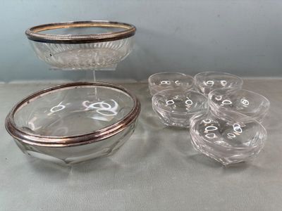 un saladier en verre et six verres posés sur une table