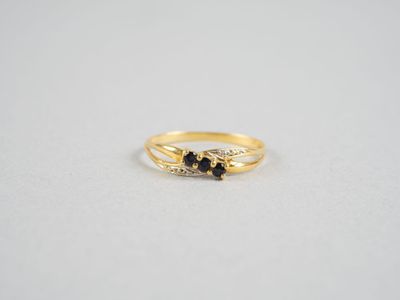 une bague en or surmontée de deux diamants noirs