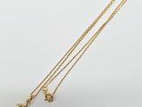 un collier plaqué or orné d'un petit pendentif en forme d'éléphant, monté sur une chaîne en or