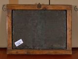 a blackboard with a sticker on it sitting on a table