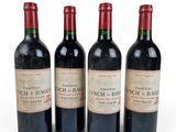 three bottles of red wine sit next to each other on a white surface