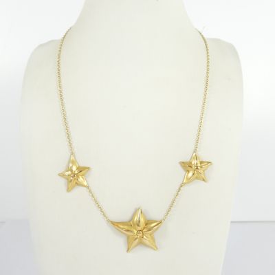 a close up of a gold necklace on a mannequin mannequin
