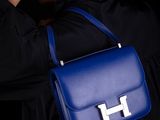 the woman is wearing a black shirt and a blue handbag